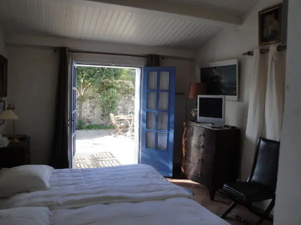 Lit king-size de la chambre Côté Bateau, porte ouverte sur la terrasse