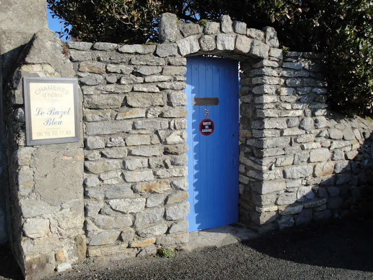 L'entrée du Buzet Bleu, porte bleue dans un mur de pierre